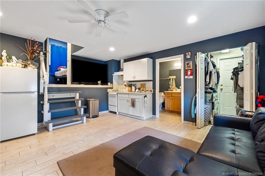 15848 129th Terrace North Jupiter, FL 33478 - Photo 36 of 52 a living room with furniture a flat screen tv and a refrigerator