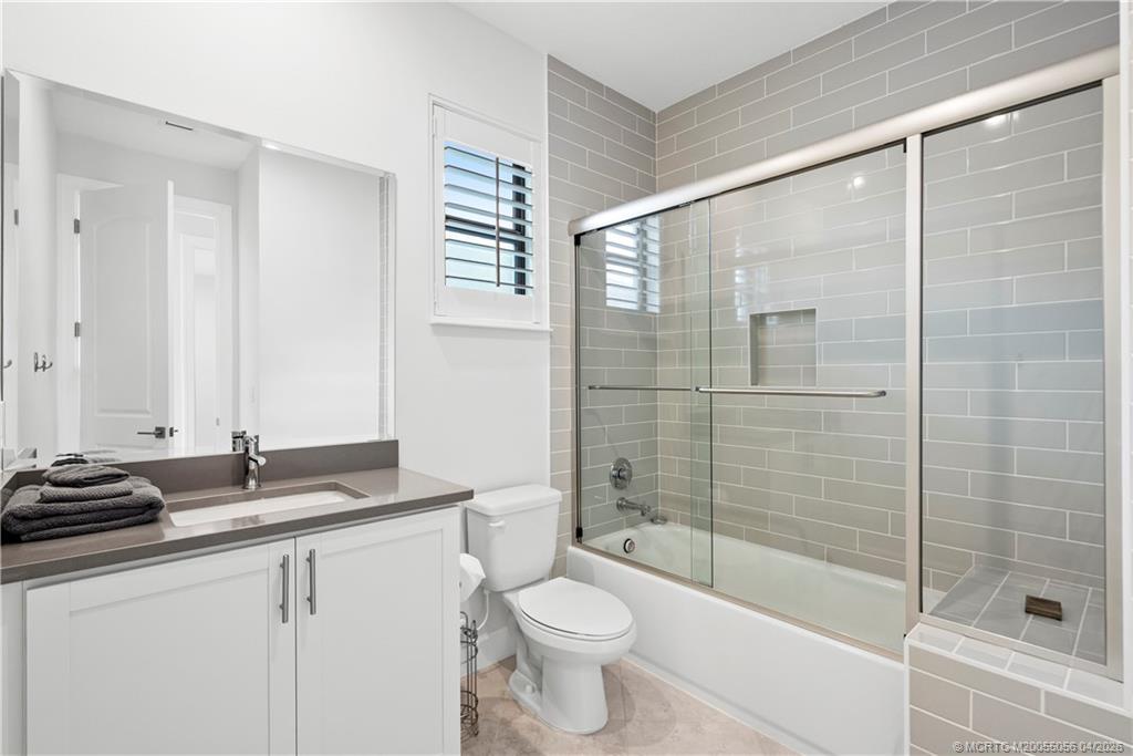 3660 Magnolia Rdg Lane Palm City, FL 34990 - Photo 24 of 35 a bathroom with a bathtub shower sink mirror and toilet