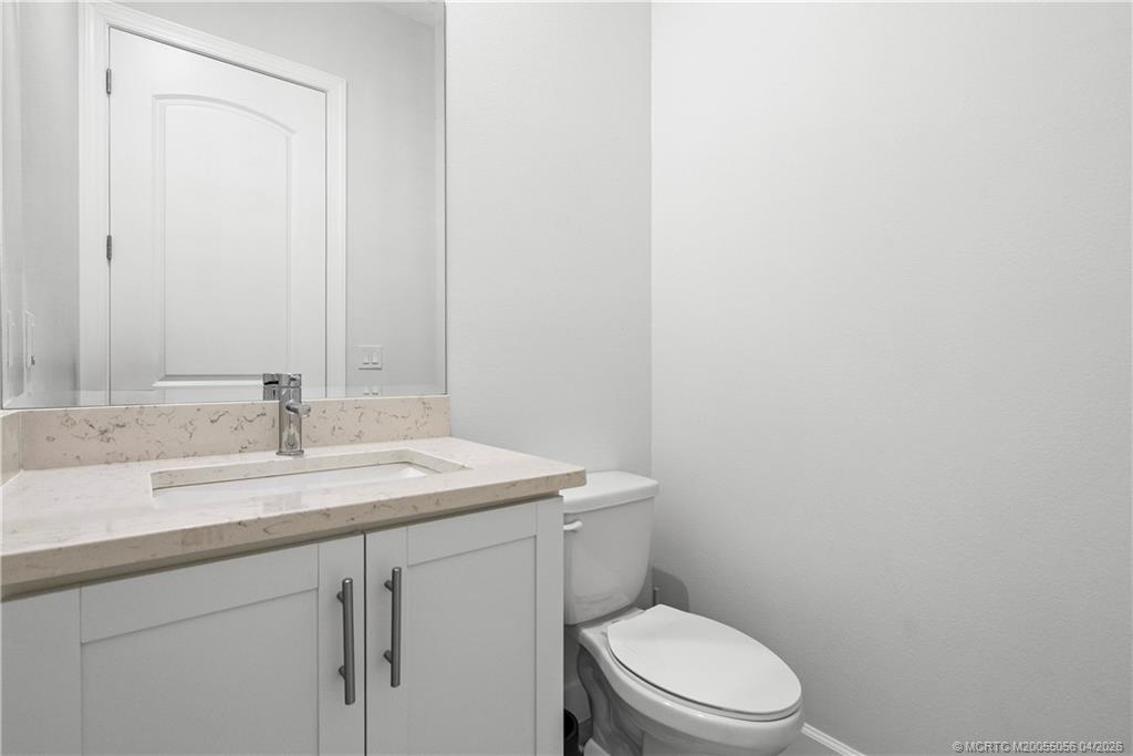 3660 Magnolia Rdg Lane Palm City, FL 34990 - Photo 9 of 35 a bathroom with a granite countertop toilet sink and mirror