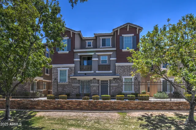 a front view of a house with trees and plants