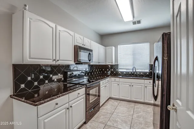 a kitchen with stainless steel appliances granite countertop a sink stove and cabinets