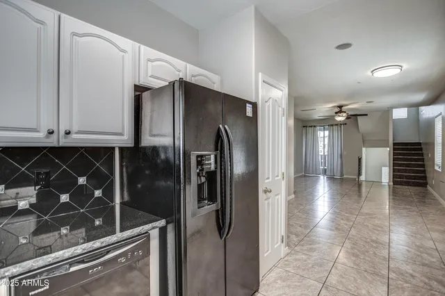 a view of a refrigerator and cabinets in a kitchen