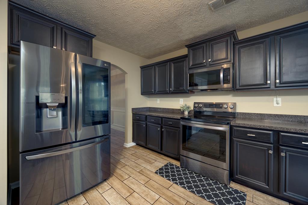 43 Ottawa Trail Fort Mitchell, AL 36856 - Photo 17 of 57 a kitchen with granite countertop a refrigerator and a stove top oven