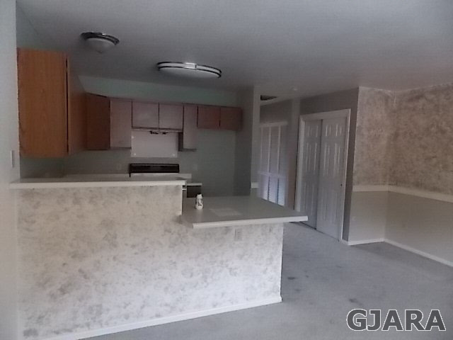 406 Ridges Boulevard, Unit 30 Grand Junction, CO 81507 - Photo 3 of 11 a kitchen with kitchen island a counter top space a sink and cabinets