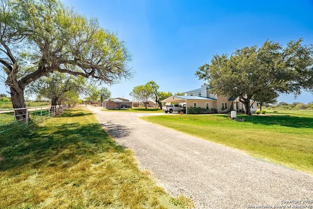 an aerial view of a house with a garden and lake view