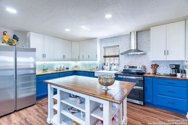 a kitchen with stainless steel appliances granite countertop a sink a stove and wooden cabinets