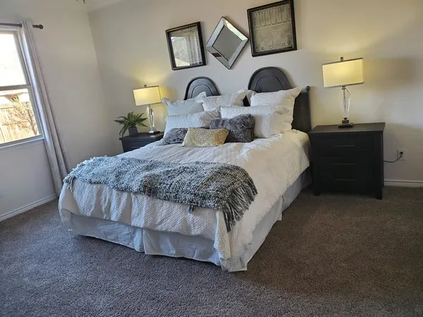 a bedroom with a bed and a lamp on table