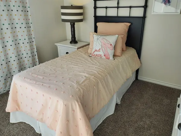 a bed sitting in a bedroom next to a lamp