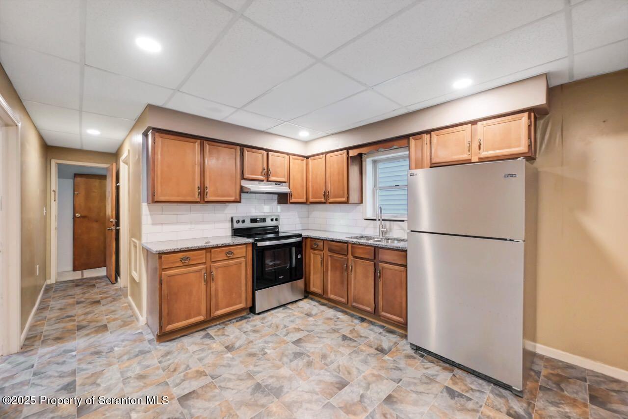 601 Dean Street Scranton, PA 18509 - Photo 13 of 58 a kitchen with granite countertop a refrigerator stove top oven and sink