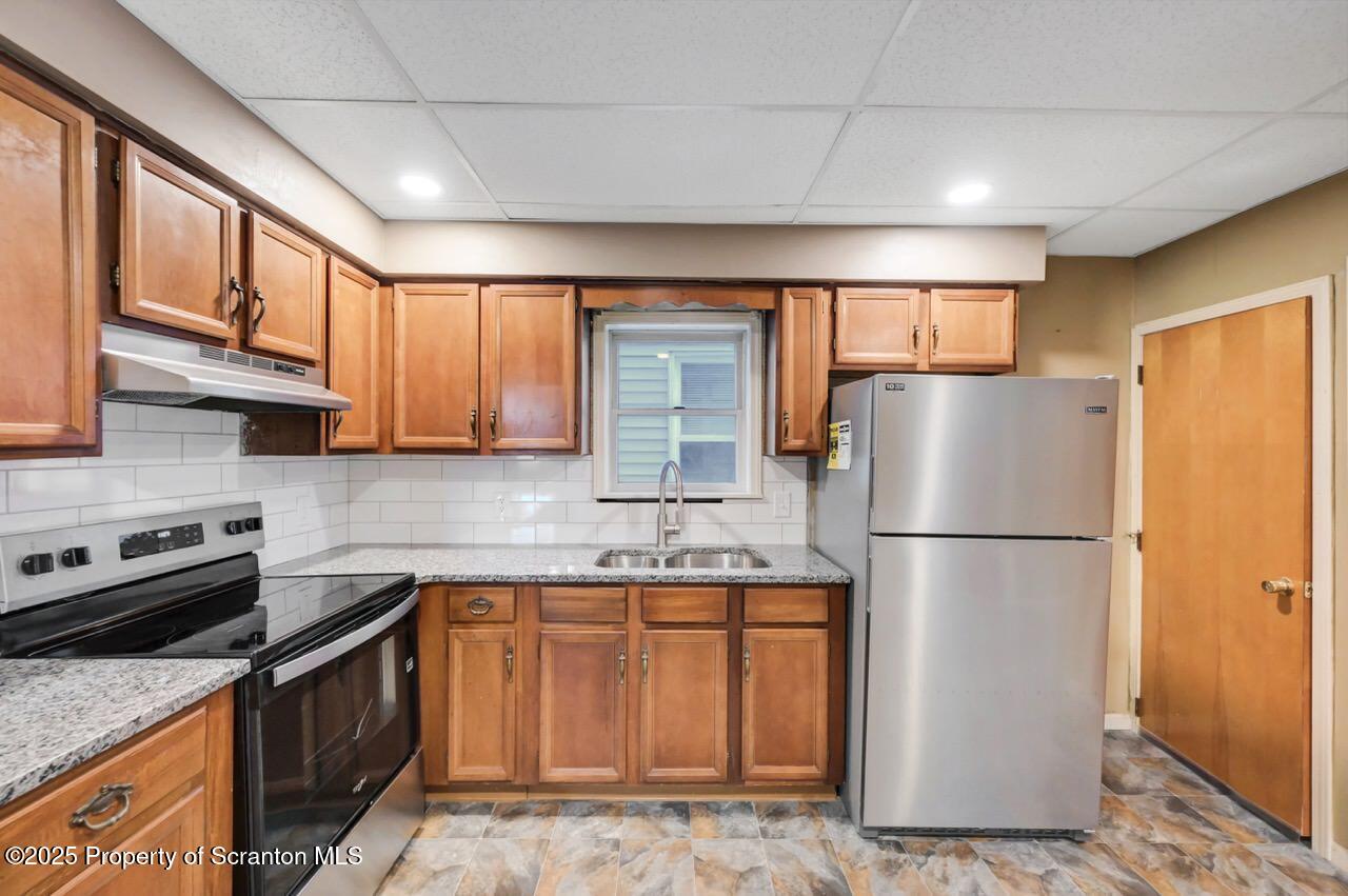601 Dean Street Scranton, PA 18509 - Photo 14 of 58 a kitchen with a refrigerator a stove top oven a sink and cabinets