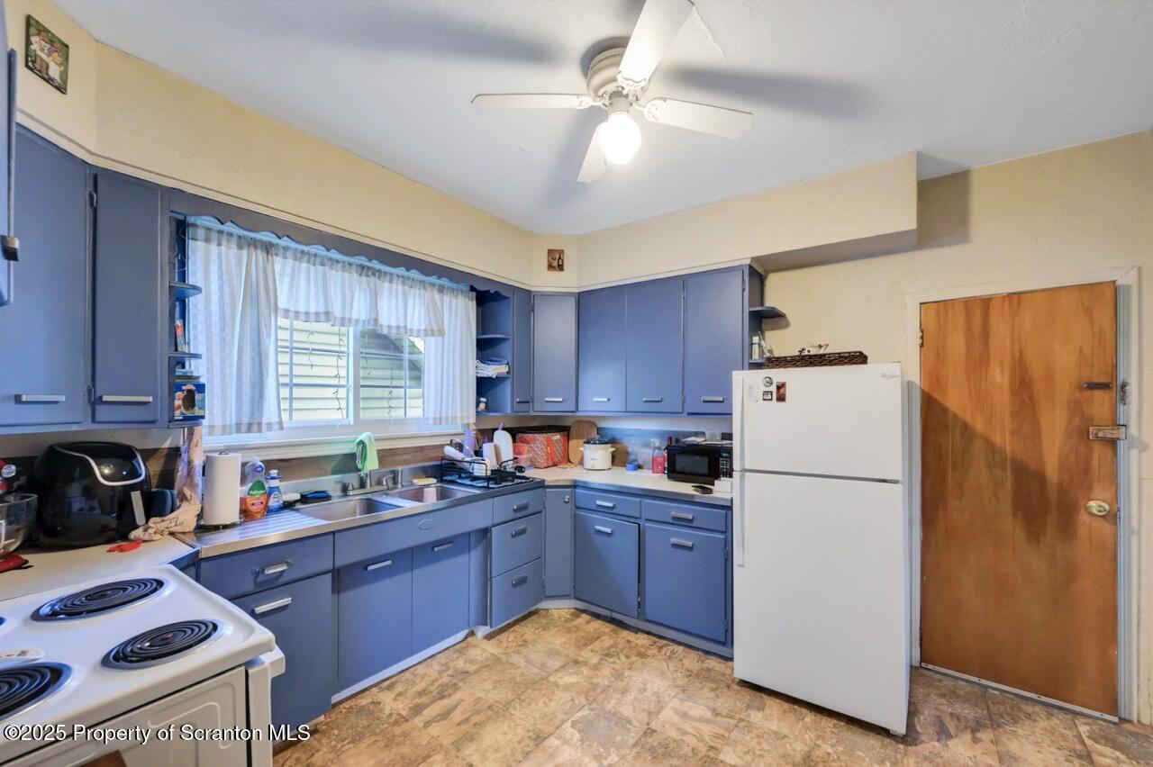 601 Dean Street Scranton, PA 18509 - Photo 36 of 58 a kitchen with refrigerator a sink a stove a microwave and cabinets