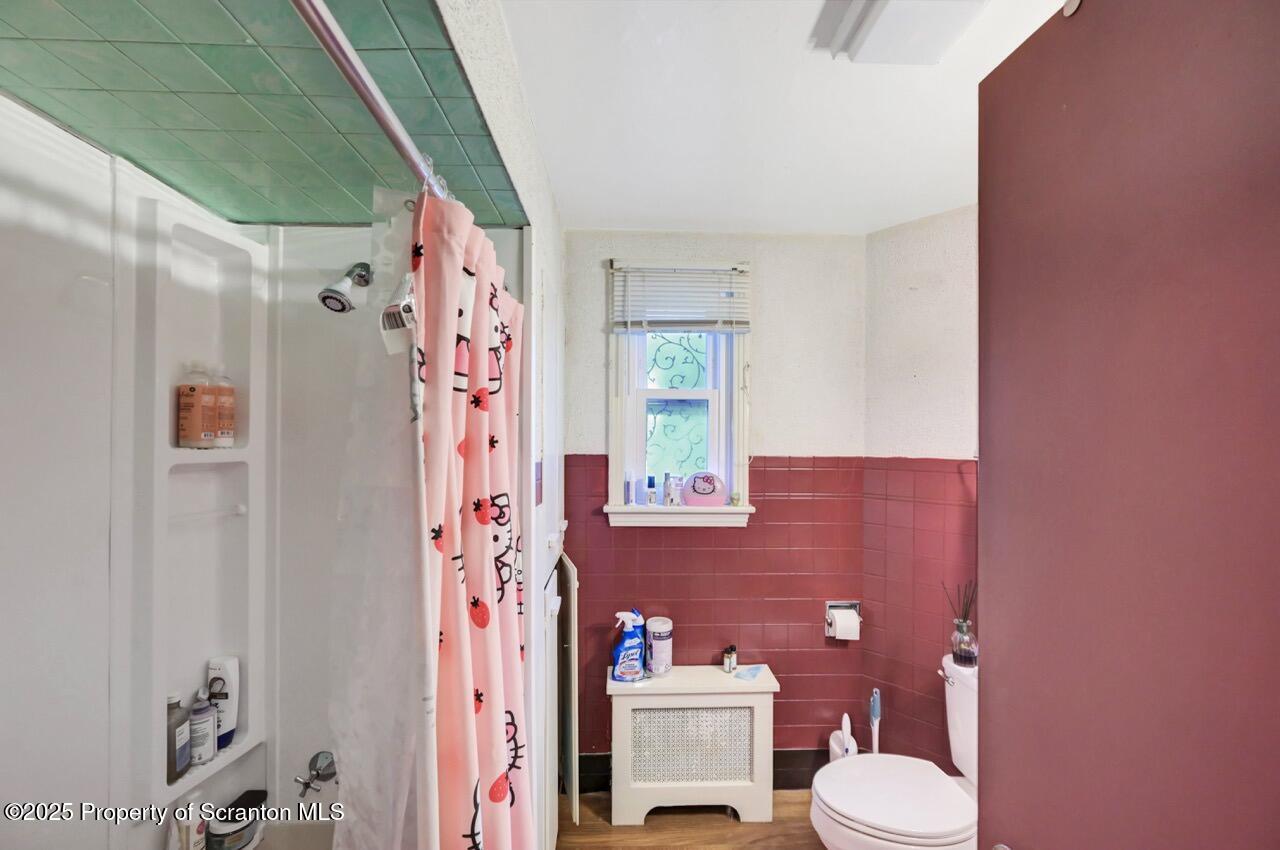 601 Dean Street Scranton, PA 18509 - Photo 39 of 58 a bathroom with a sink a toilet a shower curtain and a large mirror