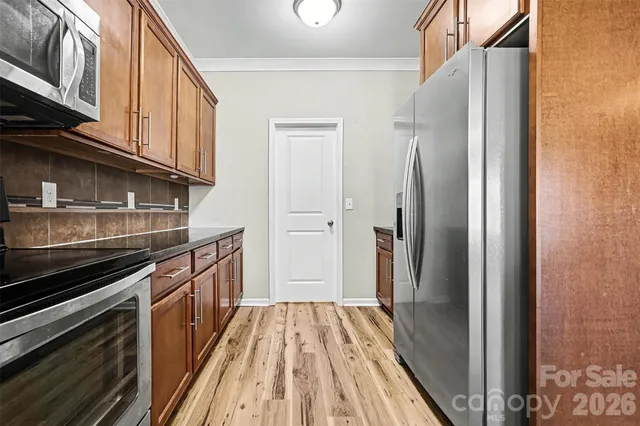 a kitchen with stainless steel appliances granite countertop a refrigerator and a stove top oven