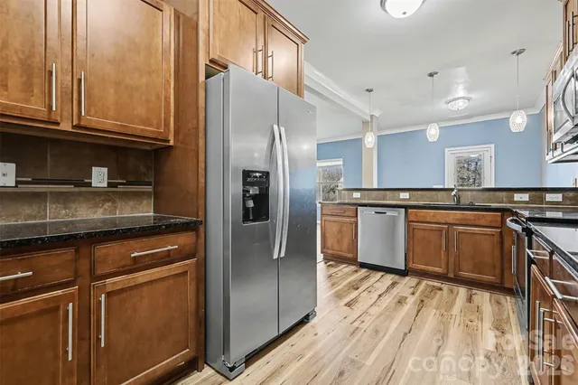 a kitchen with stainless steel appliances granite countertop a refrigerator and a sink
