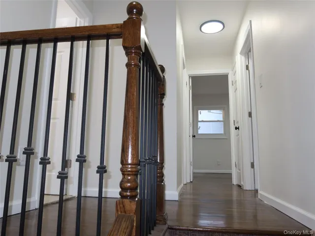 a view of a hallway with wooden floor and staircase