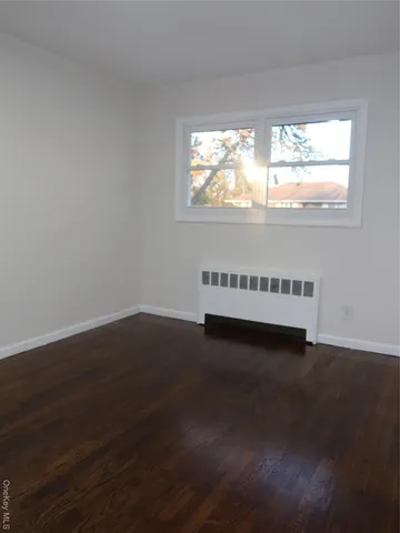 a view of a livingroom with wooden floor and window