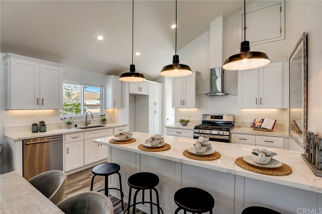 4566 166th Street Lawndale, CA 90260 - Photo 12 of 64 a kitchen with stainless steel appliances granite countertop a stove a sink and a dining table with chairs