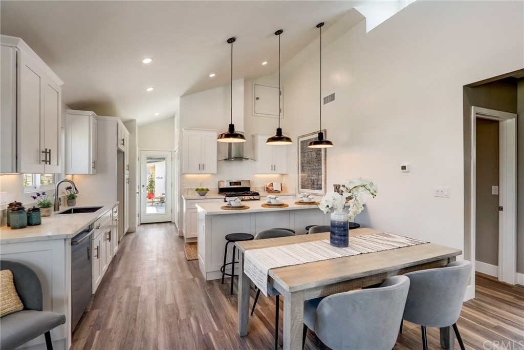 4566 166th Street Lawndale, CA 90260 - Photo 16 of 64 a kitchen with kitchen island a stove a table a sink refrigerator and cabinets