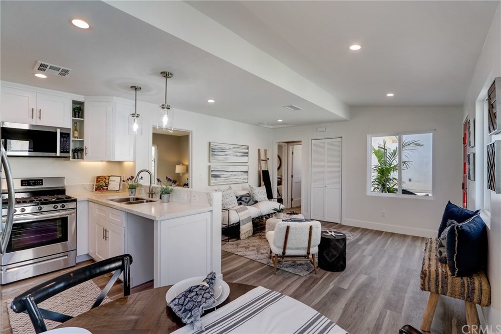 4566 166th Street Lawndale, CA 90260 - Photo 20 of 64 a kitchen with stainless steel appliances a stove a sink a refrigerator white cabinets and wooden floor