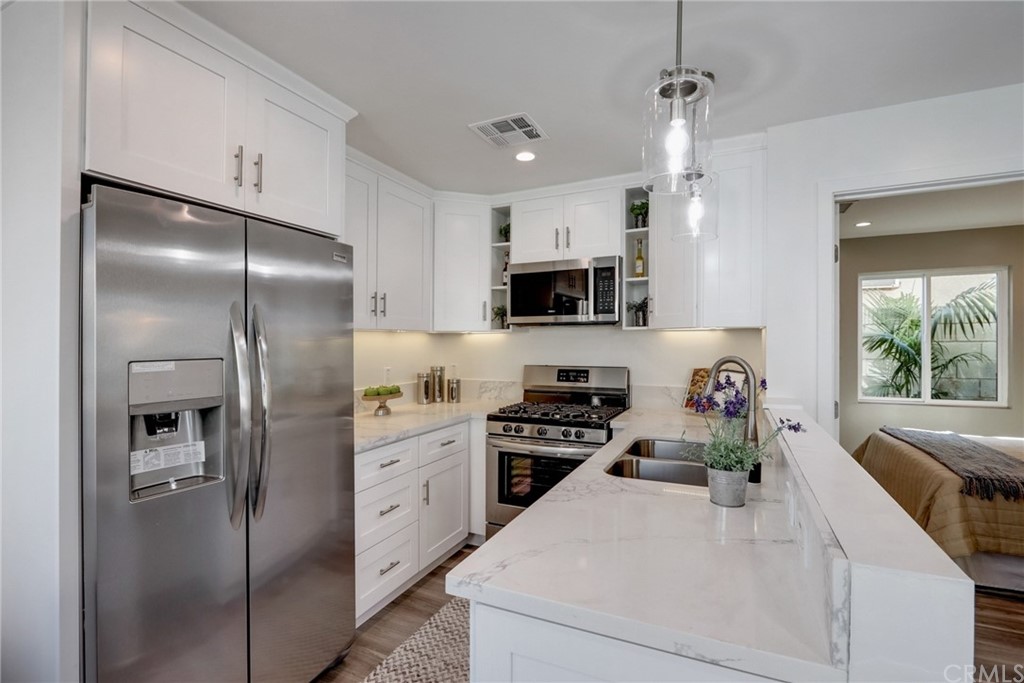 4566 166th Street Lawndale, CA 90260 - Photo 34 of 64 a kitchen with cabinets a sink stainless steel appliances and a window