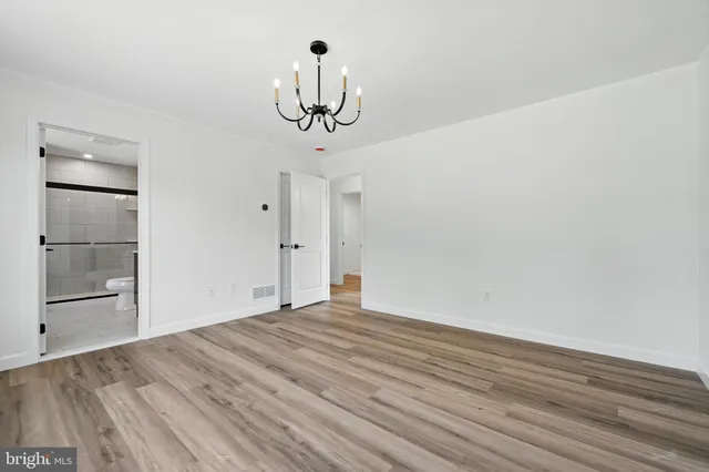 a view of empty room with wooden floor and ceiling fan