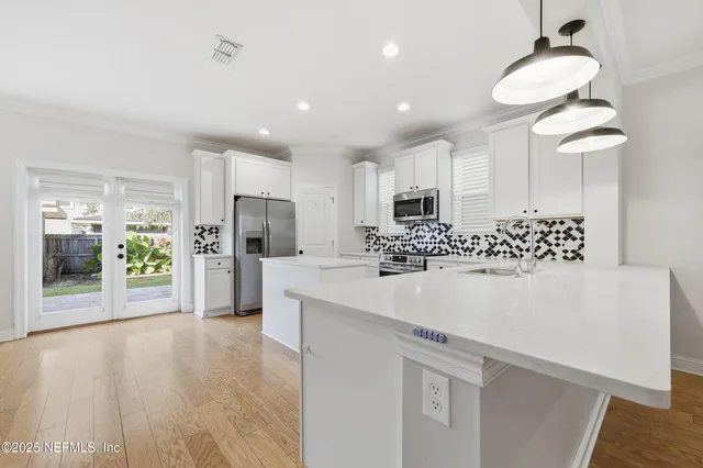 a view of kitchen with stainless steel appliances a refrigerator and a stove top oven