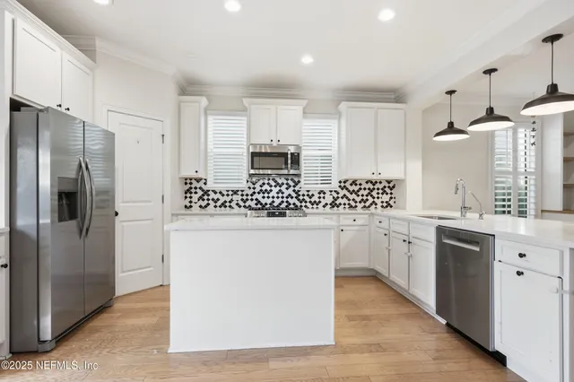 a view of kitchen with sink stainless steel appliances and cabinets