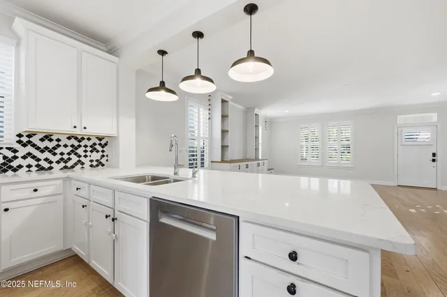 a kitchen with a sink dishwasher and a stove with wooden floor