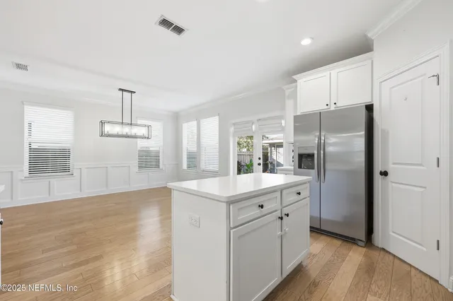 a kitchen with a refrigerator a sink and dishwasher with wooden floor