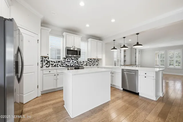 a kitchen with white cabinets and stainless steel appliances
