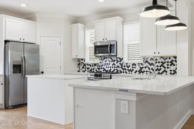 a kitchen with stainless steel appliances a sink and a refrigerator