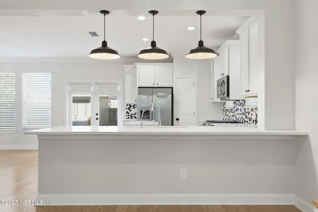 a view of a kitchen with kitchen island a counter top a stove and a window
