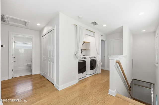 a view of a kitchen with fridge and wooden floor