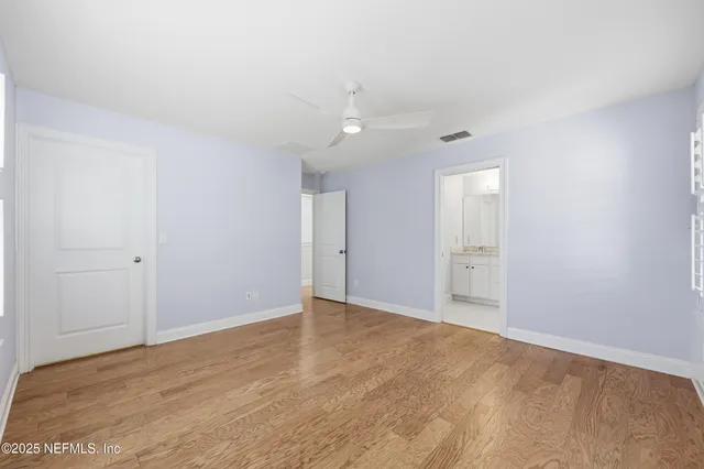a view of an empty room with wooden floor and a cabinet