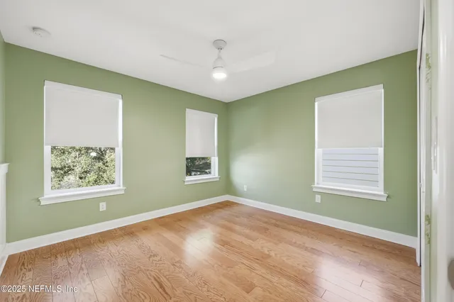 a view of an empty room with a window and closet area
