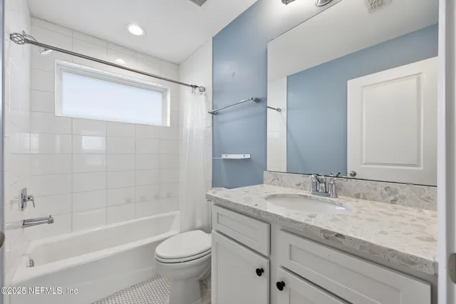 a bathroom with a granite countertop sink a toilet and shower