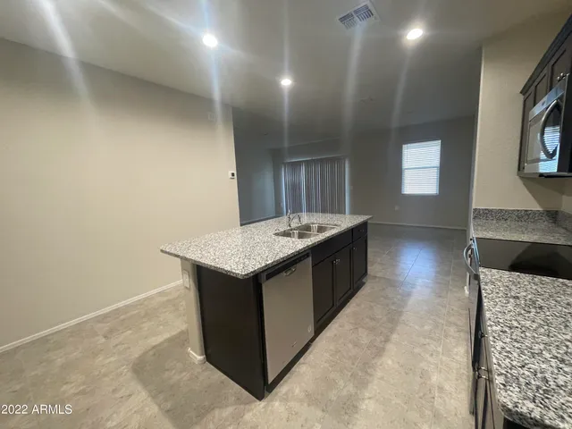 a kitchen with granite countertop sink and cabinets