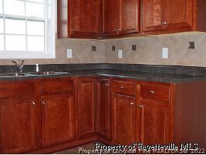 134 Wallflower Road Raeford, NC 28376 - Photo 5 of 9 a kitchen with stainless steel appliances granite countertop wooden cabinets a sink and dishwasher
