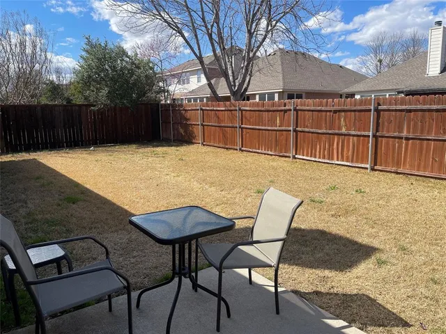 a view of a chairs and table in the backyard