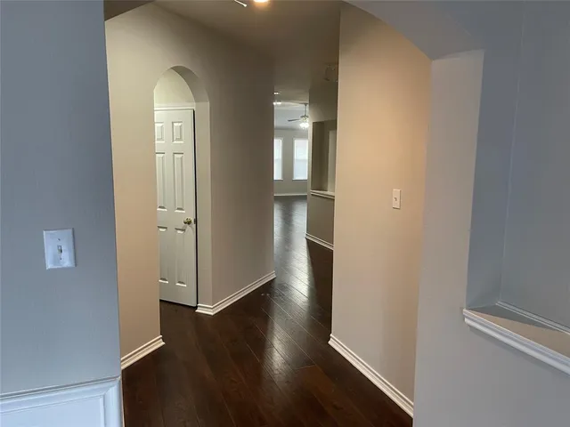 an empty room with wooden floor closet and windows