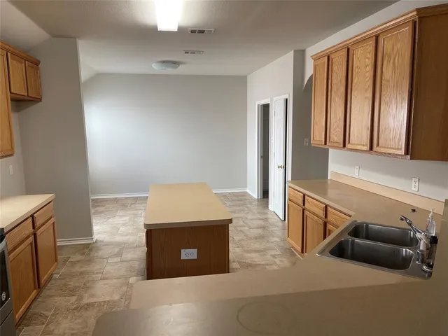 a living room with stainless steel appliances furniture a rug and a window