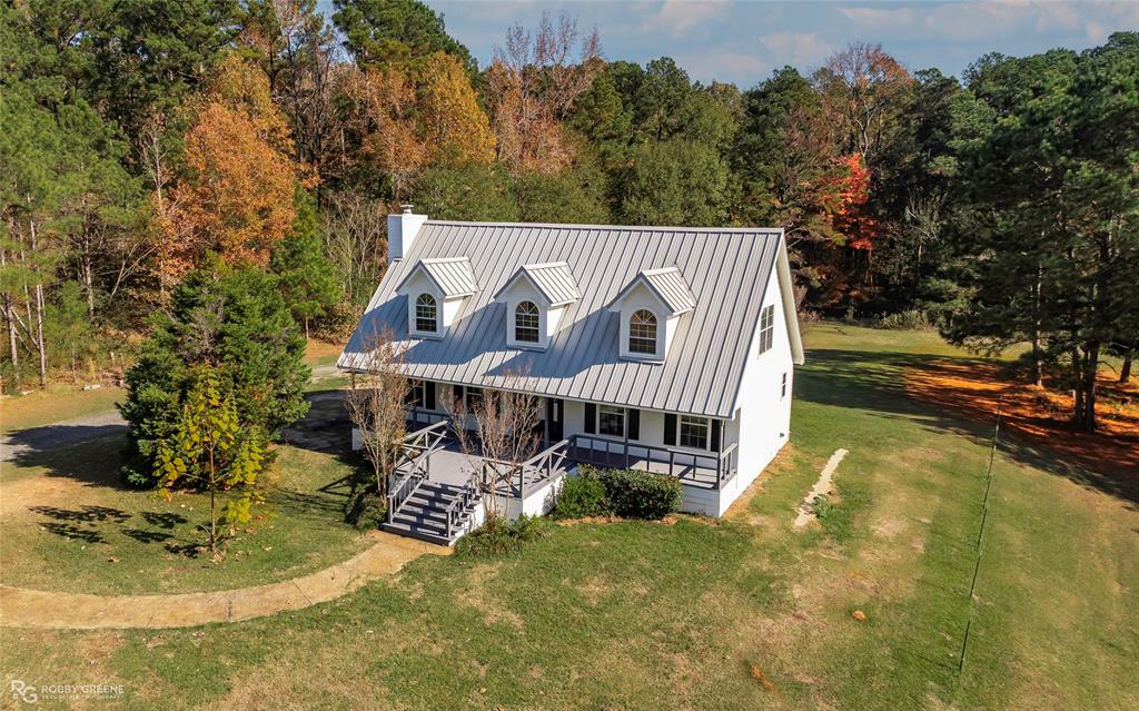 a view of a house with pool and trees in the background