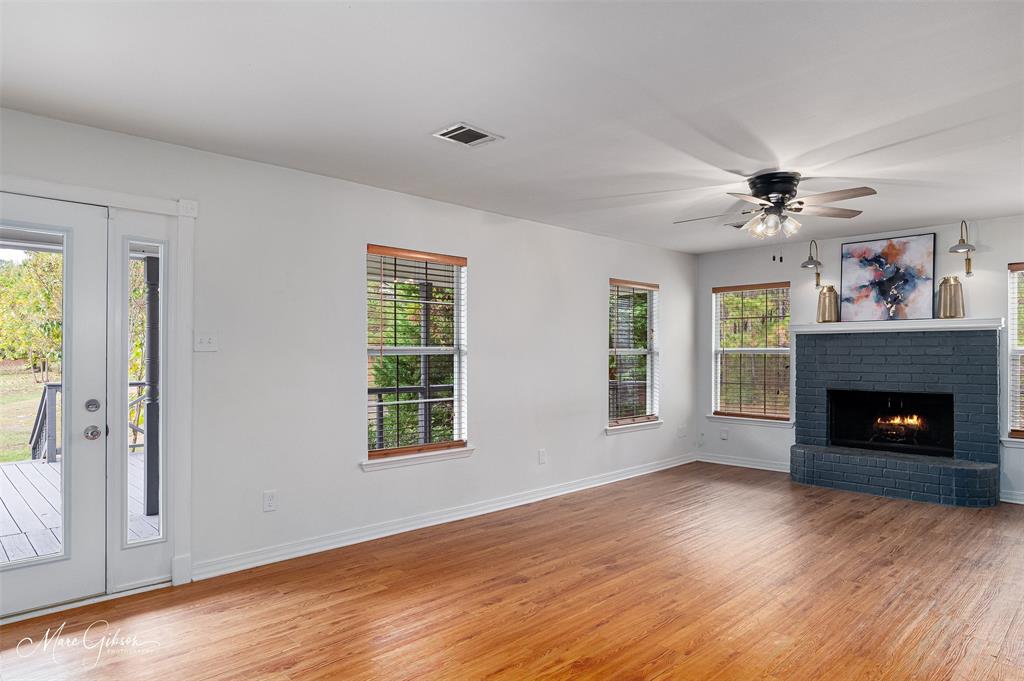 1140 Linton Road Benton, LA 71006 - Photo 6 of 39 a view of an empty room with wooden floor fireplace and a window
