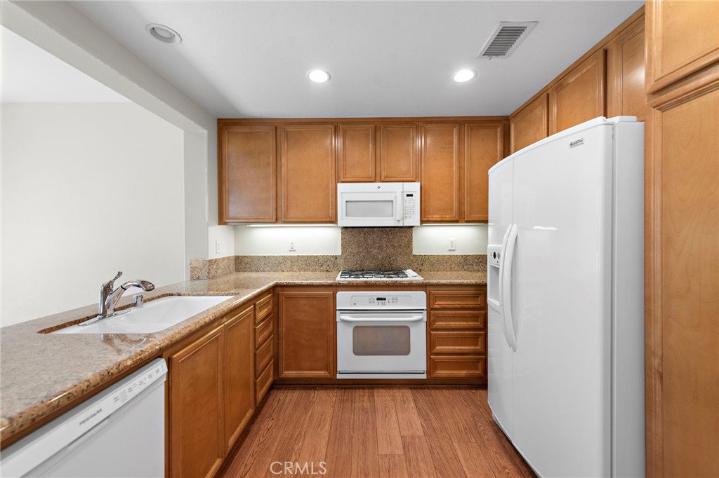 31 Notchbrook Lane Ladera Ranch, CA 92694 - Photo 6 of 24 a kitchen with a sink a refrigerator a microwave and cabinets