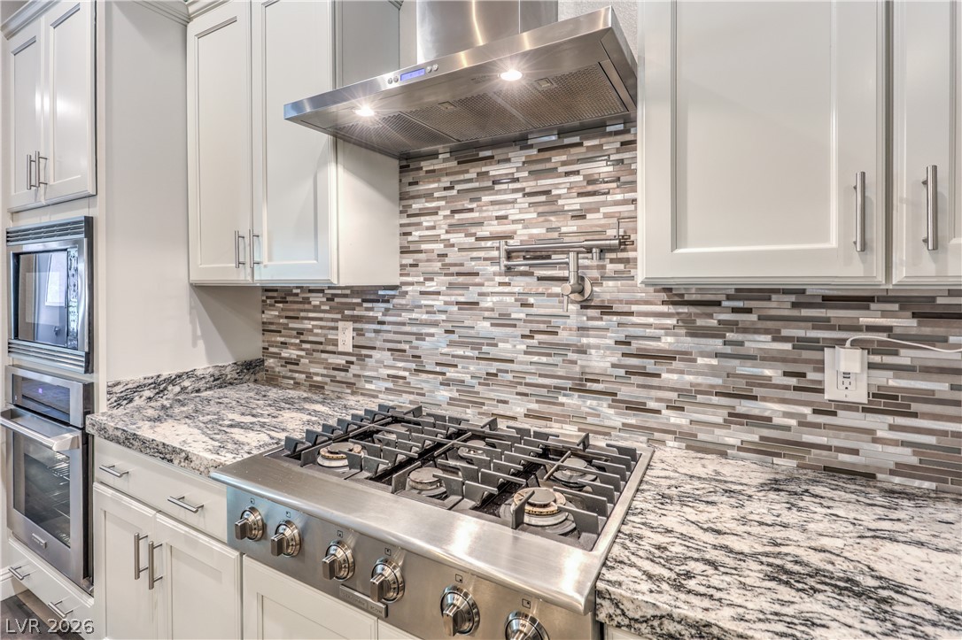 7119 Arabian Ridge Street Las Vegas, NV 89131 - Photo 16 of 73 Premium granite countertops complement sleek stainless steel appliances in this functional kitchen.