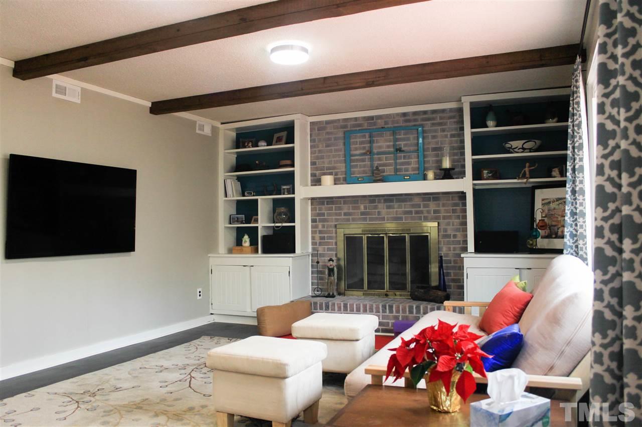 6401 Rushingbrook Drive Raleigh, NC 27612 - Photo 14 of 19 a living room with furniture fireplace and flat screen tv