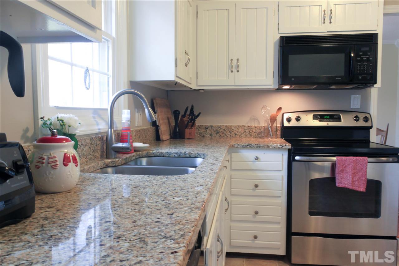 6401 Rushingbrook Drive Raleigh, NC 27612 - Photo 5 of 19 a kitchen with a stove microwave and cabinets