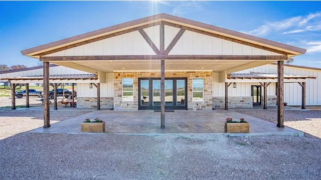 a view of the patio with dining table and chairs under an umbrella