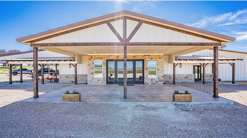 a view of the patio with dining table and chairs under an umbrella