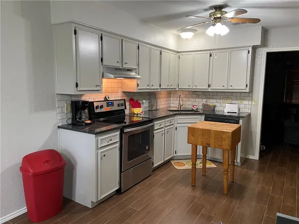 a kitchen with a sink cabinets and wooden floor